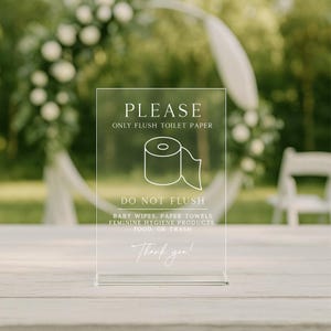 May include: Clear acrylic sign with the text "PLEASE ONLY FLUSH TOILET PAPER" and a toilet paper roll graphic. Below, it reads "DO NOT FLUSH" followed by a list of items. The sign ends with "Thank you!" in script font.