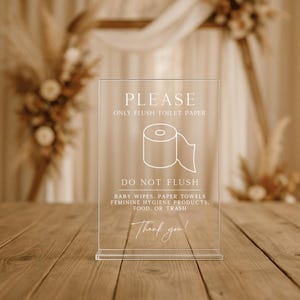 May include: Transparent acrylic sign with white text and a toilet roll graphic. The sign says "PLEASE ONLY FLUSH TOILET PAPER" and "DO NOT FLUSH" with a list of items. The sign includes "Thank you!" at the bottom.