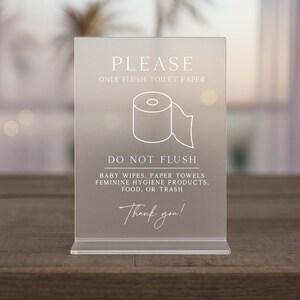 May include: A clear acrylic sign with the text "PLEASE ONLY FLUSH TOILET PAPER" and "DO NOT FLUSH" with a toilet paper roll graphic. The sign also includes a list of items not to flush and the words "Thank you!"