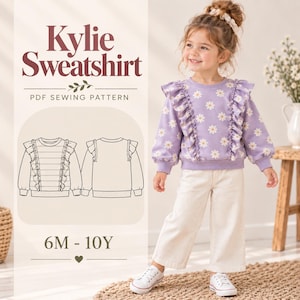 May include: A PDF sewing pattern for the Kylie Sweatshirt, featuring a light purple long-sleeve sweatshirt with a white daisy print and vertical ruffles along the front. The design includes a technical line drawing of the front and back views.