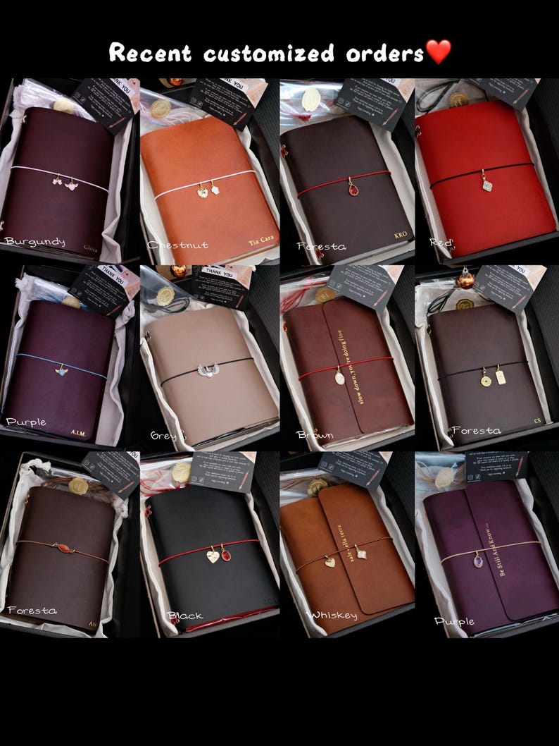 May include: A collection of twelve leather journals in various colours including burgundy, chestnut, foresta, red, purple, grey, brown, and black. Each journal features a coloured elastic band with a small metal charm and custom text.