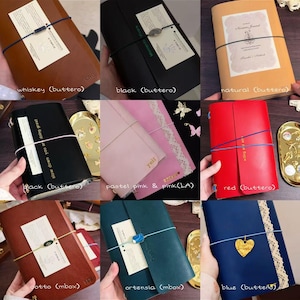 May include: A collage of nine leather journals in various colours including whiskey, black, natural, pastel pink, red, cotto, ortensia, and blue. Each journal features an elastic band closure, some with decorative charms, lace trim, or printed text.