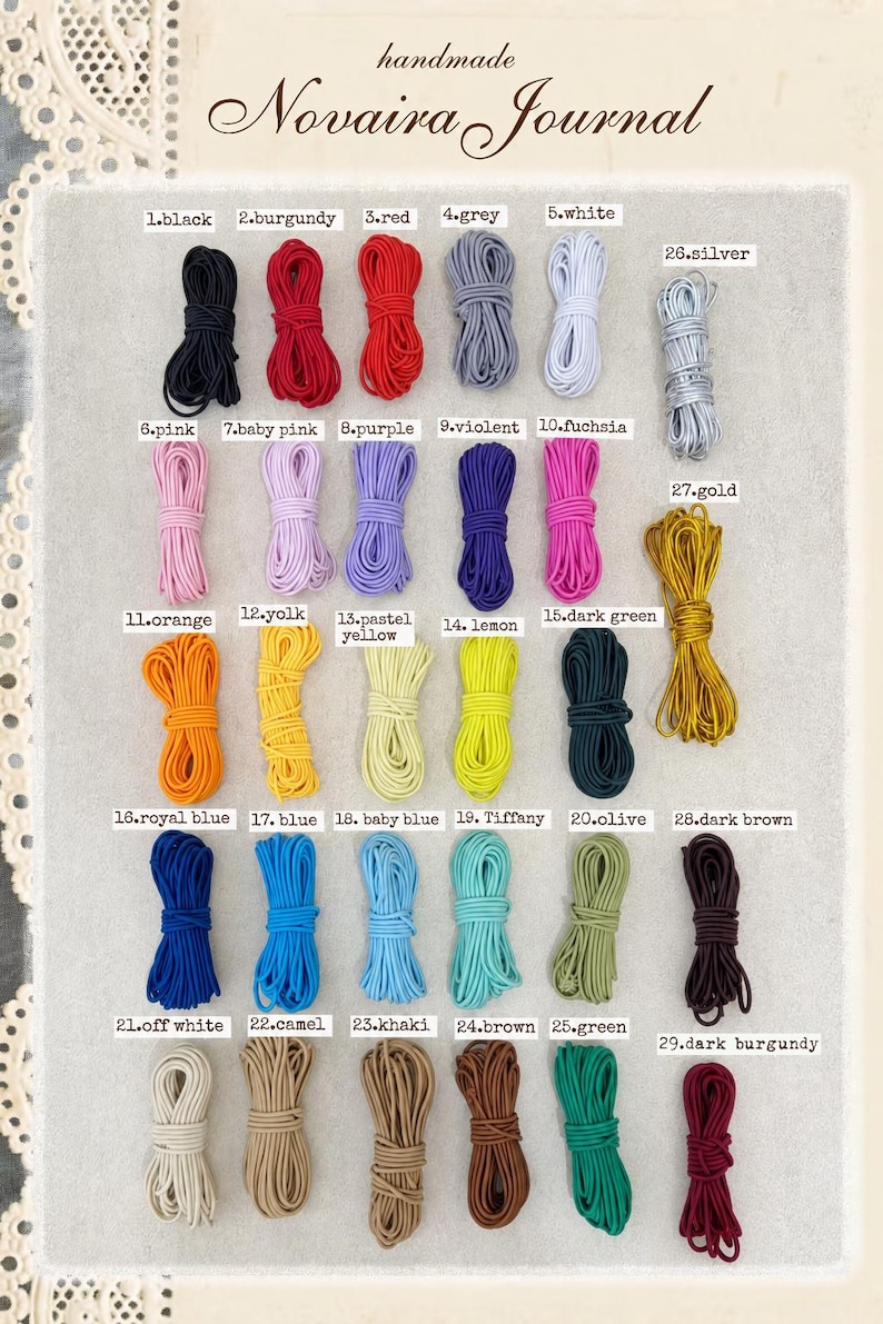 May include: A collection of 29 bundles of elastic cord in various colours, labelled with numbers 1 through 29. The colours include black, burgundy, red, grey, white, silver, pink, purple, fuchsia, gold, orange, yellow, green, blue, and brown.