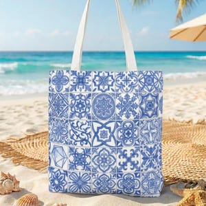 May include: A tote bag featuring a grid pattern of blue and white tiles with various intricate geometric and floral motifs. The bag has two white shoulder straps and is constructed from a fabric material with a repeating square tile design.