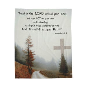 May include: A white blanket with a scenic landscape and a cross. The blanket features the text "Trust in the LORD with all your HEART" and a quote from Proverbs 3:5-6. The image includes a road, trees, and a cross.