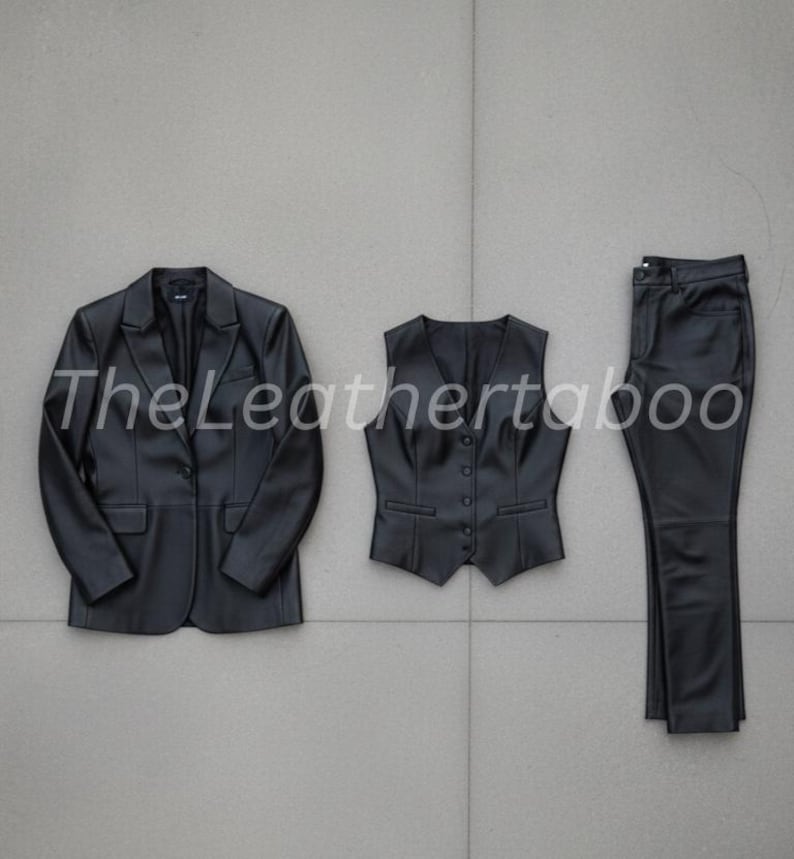 May include: A three-piece black leather suit set, including a blazer, vest, and pants. The blazer has a two-button closure, the vest has a button-down front, and the pants are straight-legged. The set is displayed on a gray tiled surface.