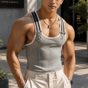 May include: A striped tank top with suspender straps and metal hardware. The tank top features vertical stripes in shades of gray and white. The model is wearing khaki pants and a silver necklace.