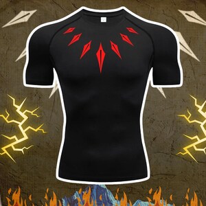 Könnte beinhalten: Schwarzes Kompressions-T-Shirt mit Rundhalsausschnitt und kurzen Ärmeln. Das T-Shirt hat ein rotes geometrisches Design auf der Brust. Das T-Shirt besteht aus einem dehnbaren, sportlichen Material.