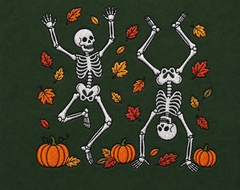 May include: An embroidered design on a dark green fabric featuring two white skeletons in playful poses surrounded by scattered orange, red, and yellow autumn leaves. Three orange pumpkins are positioned along the bottom of the embroidery.