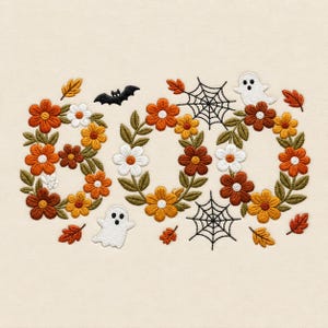 May include: An embroidery design featuring the word BOO spelled out with orange, yellow, and white flowers and green leaves. The design includes two white ghosts, a black bat, two black spiderwebs, and scattered orange and brown autumn leaves.