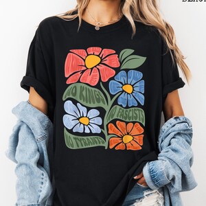May include: Black t-shirt featuring a floral design with the text "NO KINGS NO FASCISTS NO TYRANTS." The graphic includes red, blue, and orange flowers with yellow centers and green leaves. The shirt is a comfortable, casual style.