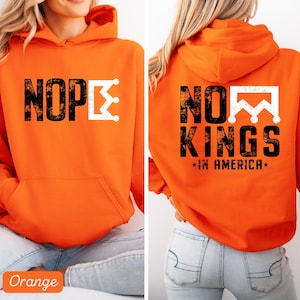May include: Orange hoodie with the text "NOPE" and a white crown graphic on the front. The back of the hoodie features the text "NO KINGS *IN AMERICA*" with a white crown graphic. The hoodie has a front pocket and a hood.