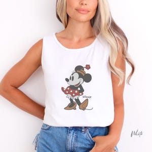 Peut inclure: D&eacute;bardeur blanc avec un motif de Minnie Mouse. Le personnage de dessin anim&eacute; porte une robe &agrave; pois rouges et blancs, des chaussures marron et un chapeau assorti. Le logo Disney est imprim&eacute; en dessous.