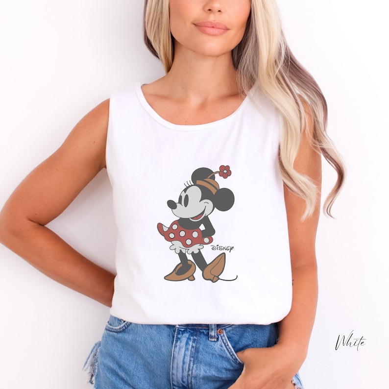 Peut inclure: D&eacute;bardeur blanc avec un motif de Minnie Mouse. Le personnage de dessin anim&eacute; porte une robe &agrave; pois rouges et blancs, des chaussures marron et un chapeau assorti. Le logo Disney est imprim&eacute; en dessous.