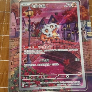 May include: A Pok&eacute;mon trading card featuring two Cubone characters on a bridge with a scenic background. The card has Japanese text and a HP of 70. The card is encased in a clear protective sleeve.