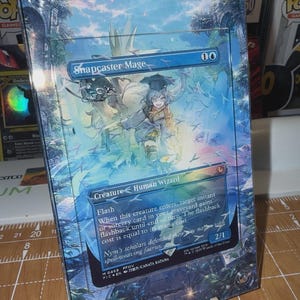 May include: A white ceramic mug with a black handle and the text "But First, Coffee" in a black, bold font. The mug is sitting on a wooden surface. The mug is approximately 4 inches tall.