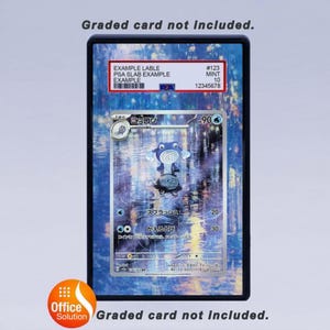Op de afbeelding: Een beoordeelde kaart in een zwarte hoes. De kaart toont een blauw en wit stripfiguur. De hoes heeft een label met de tekst "EXAMPLE LABLE PSA SLAB EXAMPLE EXAMPLE #123 MINT 10 12345678". De tekst "Graded card not included" is ook aanwezig.