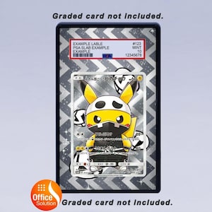 Pode incluir: Um cart&atilde;o classificado em uma caixa preta. O cart&atilde;o apresenta um personagem Pikachu amarelo usando uma m&aacute;scara de caveira. A caixa tem um fundo prateado padronizado e um r&oacute;tulo com o texto "EXAMPLE LABLE". O texto "Graded card not included" tamb&eacute;m est&aacute; presente.