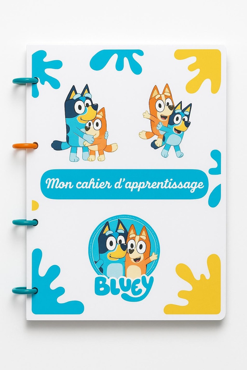 May include: A spiral-bound notebook featuring illustrations of Bluey and Bingo, the cartoon dogs. The cover has the text "Mon cahier d'apprentissage" and the word "Bluey". The notebook has blue and orange accents.