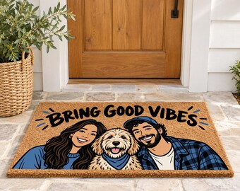 May include: A rectangular tan coir doormat featuring a cartoon illustration of a person with long dark hair, a fluffy golden dog wearing a blue bandana, and a person with a beard and blue cap, with the text BRING GOOD VIBES.