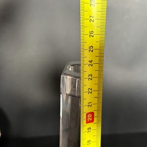 May include: A pair of silver-colored, hexagonal candle holders. A yellow ruler is placed next to one, showing a height of approximately 9 inches. The candle holders have a modern, geometric design.