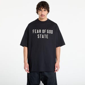 May include: Black t-shirt with the text "FEAR OF GOD STATE" in white block letters. The shirt has short sleeves and a crew neck. The model is wearing black pants.