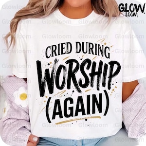 Puede incluir: Camiseta blanca con la frase "Cried During Worship (Again)" en letras negras. El diseño incluye detalles dorados y el nombre de la marca "Glowloom". Una prenda de vestir informal.