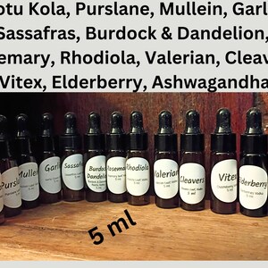 May include: A collection of small, brown glass dropper bottles with black caps, each labeled with a different herbal name. The labels include names like Gotu Kola, Valerian, and Elderberry. The text "5 ml" is also visible.