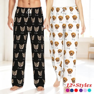 Puede incluir: Dos pares de pantalones de pijama. Un par es negro con caras de gato y el nombre "Cookie" impreso. El otro par es blanco con caras de golden retriever y el nombre "Rocky" impreso. El texto "12+ Styles" está en la parte inferior.