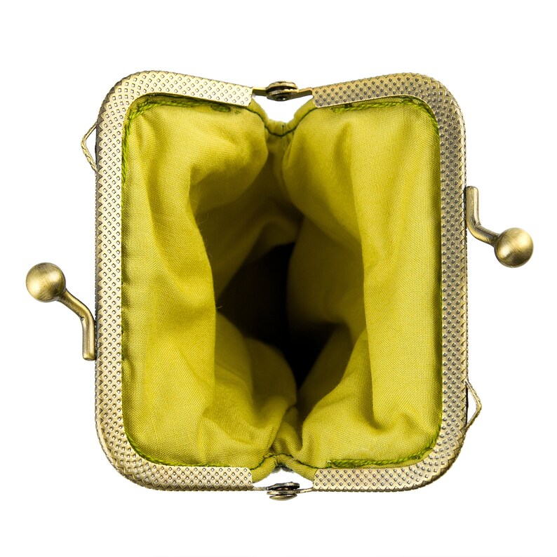 May include: A small, empty, green fabric coin purse with a gold metal frame and clasp.