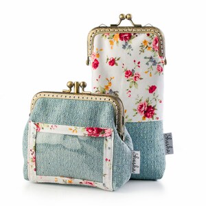 May include: Two vintage-style coin purses with kiss-lock closures. One is a small, square purse with a clear window and a floral border. The other is a tall, rectangular glasses case. Both have a blue-green textured fabric base and a floral pattern.