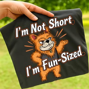 May include: Black fabric featuring the text "I'm Not Short, I'm Fun-Sized" and a cartoon illustration of an orange dog with an angry expression. The dog is wearing a black shirt.