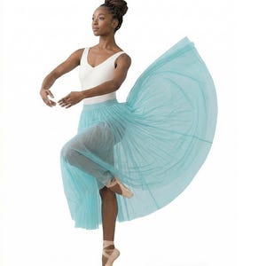 Könnte beinhalten: Eine Tänzerin in einem weißen Body und einem fließenden, hellblauen Tüllrock. Sie trägt rosa Ballettschuhe und posiert in einer anmutigen Balletthaltung. Der Hintergrund ist schlicht weiß.