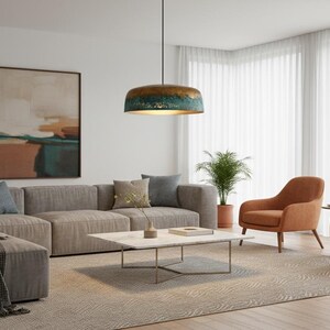 May include: A modern living room with a large gray sectional sofa, two orange armchairs, and a marble coffee table. A large abstract painting hangs on the wall, and a patterned rug covers the floor. A decorative pendant light hangs from the ceiling.