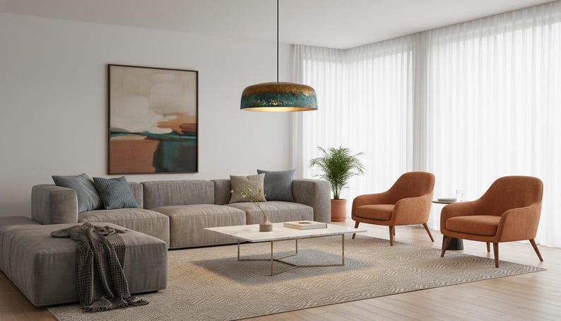 May include: A modern living room with a large gray sectional sofa, two orange armchairs, and a marble coffee table. A large abstract painting hangs on the wall, and a patterned rug covers the floor. A decorative pendant light hangs from the ceiling.