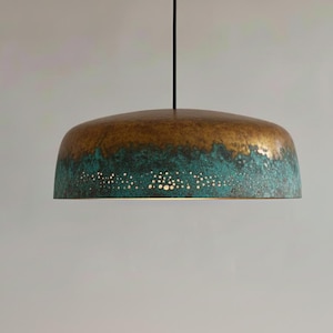 May include: A bronze and teal pendant light fixture. The top is a warm bronze color, transitioning to a teal hue at the bottom. Small, evenly spaced holes dot the teal section, allowing light to filter through.