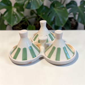 Puede incluir: Un juego de tres tazas de cerámica con acabado mate moteado. Las tazas son de color crema, gris claro y gris oscuro. Cada taza tiene un diseño simple y minimalista.