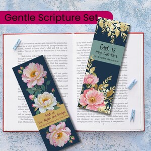 Puede incluir: Un conjunto de tres marcadores florales con texto inspirador. Los marcadores presentan un fondo azul marino con flores rosas y blancas y detalles dorados. Un marcador dice: "Dios es mi consuelo en cada estación."