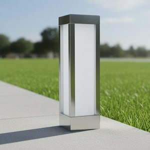 May include: A contemporary outdoor lamp post with a rectangular design. It has a stainless steel frame and a frosted white panel. The lamp is positioned on a concrete path beside a grassy area.