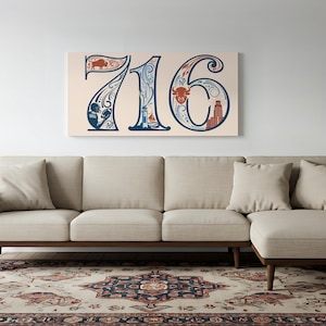 Op de afbeelding: Een beige hoekbank met een houten frame en bijpassende kussens staat op een patroonkleed. Boven de bank hangt een canvas print met het nummer "716" in een decoratief lettertype, met blauwe, rode en beige details.