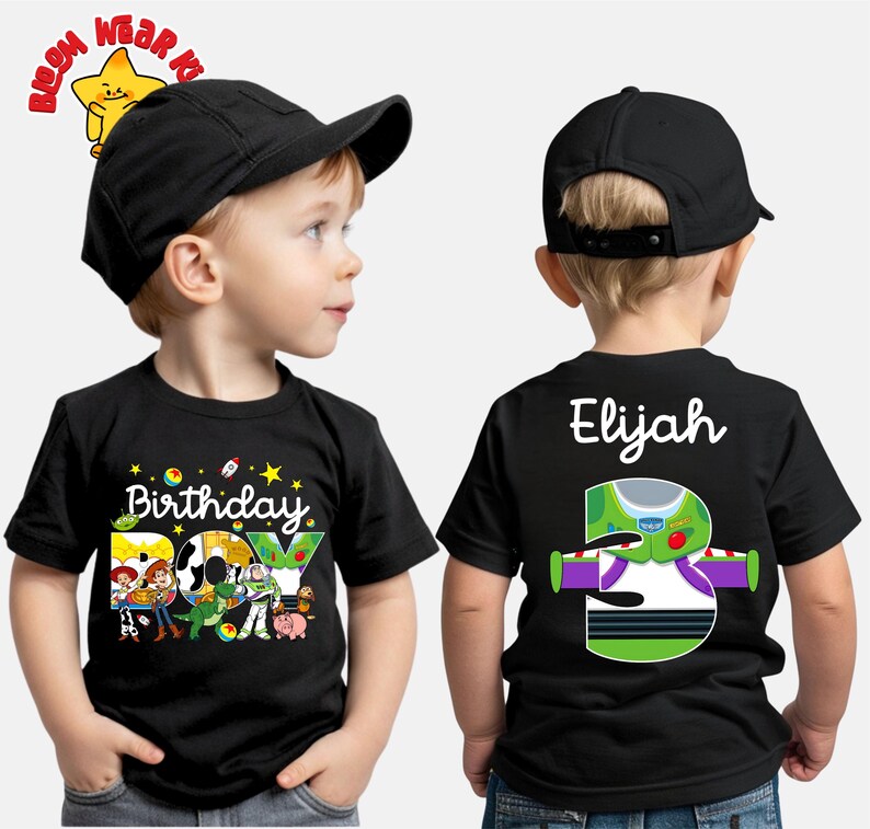 May include: Black short-sleeved t-shirt with a colorful graphic featuring characters from Toy Story and the text "Birthday Boy." The back of the shirt displays the name "Elijah" and a Buzz Lightyear design with the number "3."
