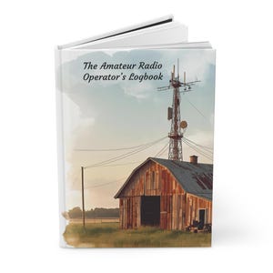Może przedstawiać: Twarda oprawa dziennika pokładowego zatytułowanego "The Amateur Radio Operator's Logbook". Okładka przedstawia ilustrację w stylu akwareli rustykalnej stodoły z wieżą radiową w tle. Niebo to miękka mieszanka błękitu i żółci.