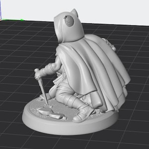 May include: A light grey 3D rendered miniature figure of a hooded character in a cloak, kneeling on a circular base. The figure holds a dagger pointed towards the ground, with visible folds in the fabric of the cloak and detailed leg armour.