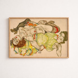 May include: A framed art print featuring a watercolor and pencil drawing of two figures in an embrace. The figures are rendered with expressive lines, muted skin tones, and accents of bright orange, yellow, and green clothing against a beige background.