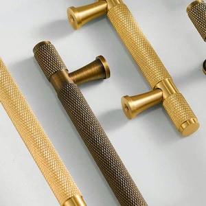 May include: A white ceramic mug with a black handle and the text "But First, Coffee" in a handwritten style. The mug is on a white surface. The mug is approximately 4 inches tall.