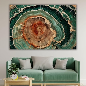 Può includere: Una stampa artistica rettangolare che mostra una sezione trasversale di un tronco d'albero con anelli concentrici in tonalità arancione scuro e marrone, circondata da motivi a strati vorticosi di verde ottanio, verde smeraldo e bianco.