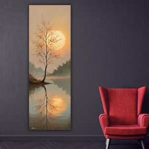 Può includere: Una stampa artistica da parete rettangolare verticale raffigurante un paesaggio con un albero solitario sulla riva di un fiume al tramonto. La scena mostra un grande sole dorato, un cielo dai toni arancio e beige e acqua calma.