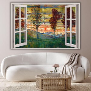 May include: A rectangular wall art piece featuring an open window frame design. The artwork displays a landscape with green hills, tall trees with reddish-brown foliage, and a sunset sky with orange and yellow hues, all framed by white window panes.