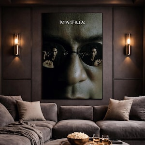 May include: A rectangular wall poster featuring a close-up of a face with dark sunglasses reflecting a person holding a pill in each lens. The word MATRIX is printed in white at the top center of the poster, which is displayed on a dark wall.