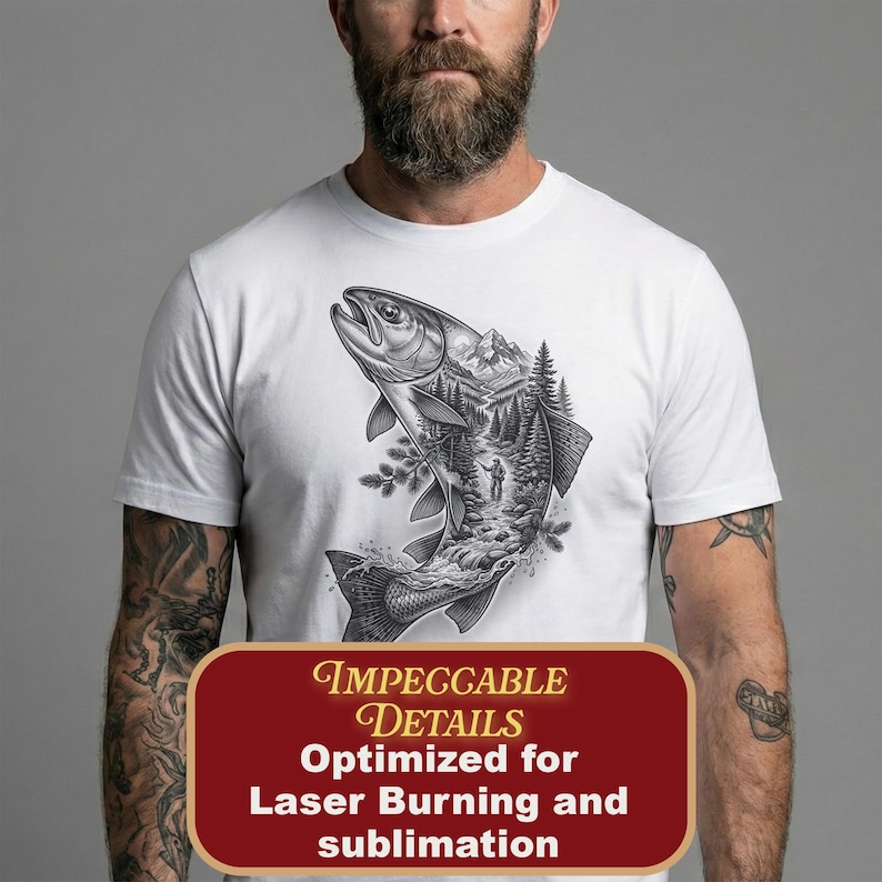 May include: A white short-sleeved t-shirt featuring a black and white graphic print of a large fish. Inside the silhouette of the fish is a detailed landscape illustration of a forest, mountains, and a person standing near a river.